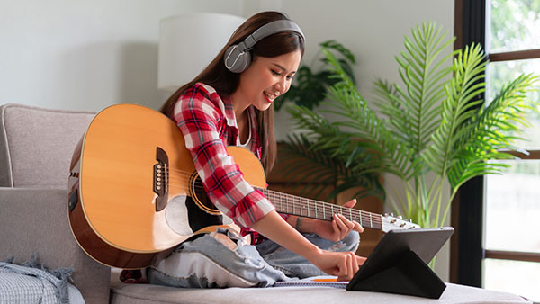 child with a smile holding a guitar